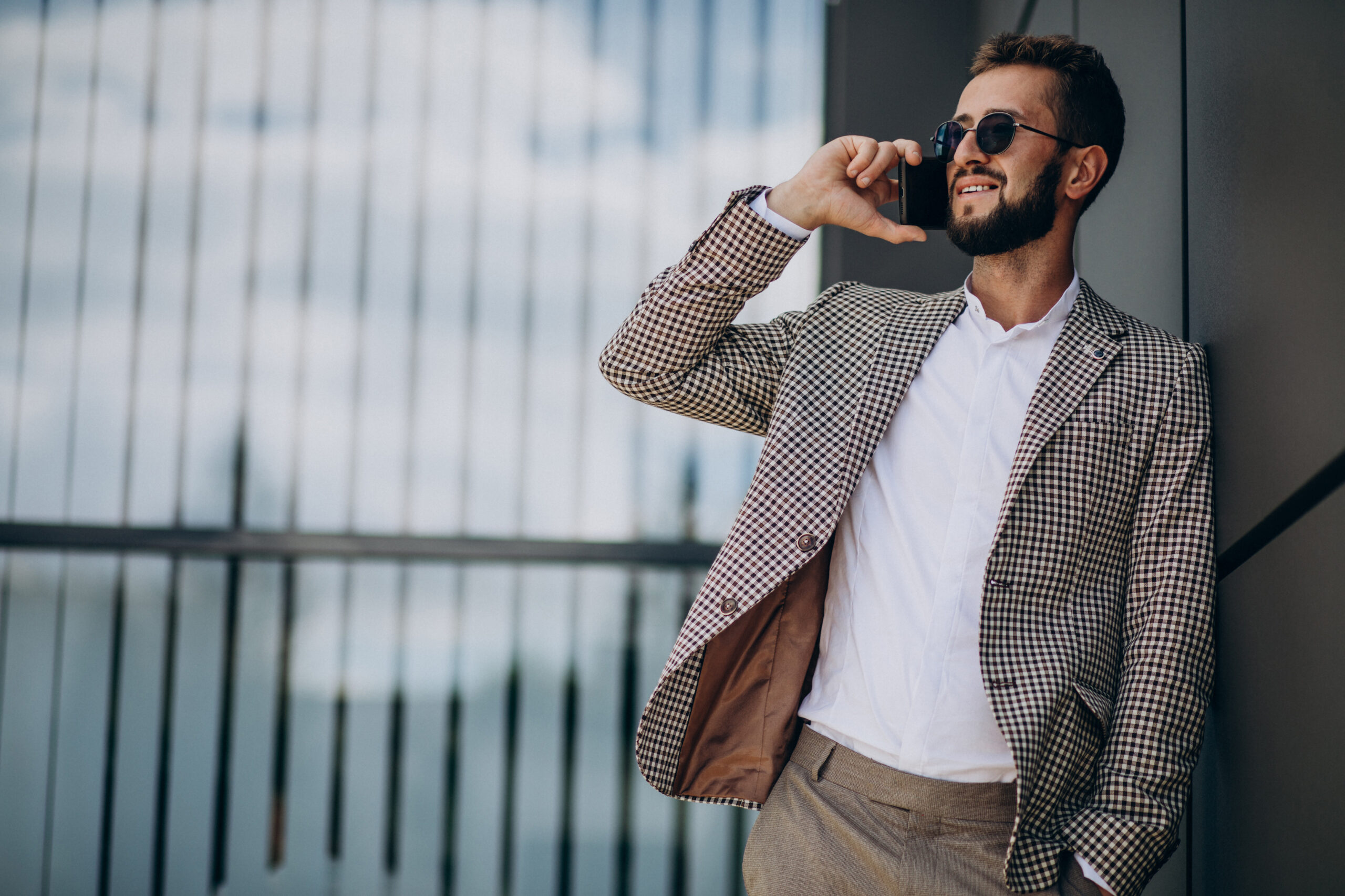 business man using phone outside office center scaled