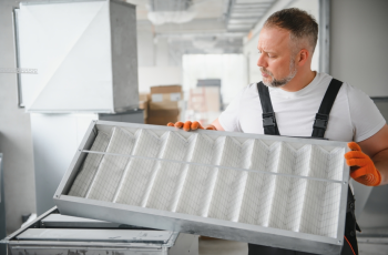 a-male-worker-holds-an-air-filter-for-air-conditio-2023-09-14-22-36-45-utc