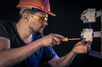 male-electrician-works-switchboard-with-electrical-connecting-cable(1)-min